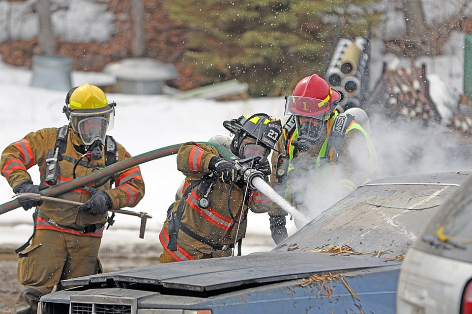 Firefighters from all over the province came to Nipawin for the Saskatchewan Volunteer Firefighters Association’s Spring School. Here, students learn how to fight a vehicle fire. Photo by Devan C. Tasa
