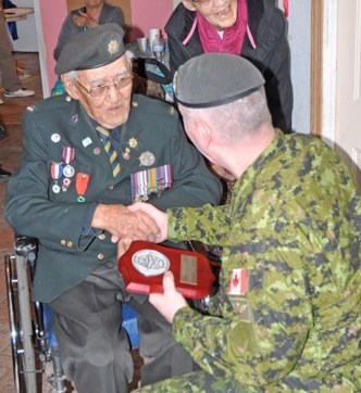 Philip Favel of Sweetgrass First Nation receives a presentation from Gen. Jonathan Vance, Canadian Armed Forces Chief of the Defence Staff, as part of his 96th birthday celebration at his home Saturday morning. For more turn to Page 10. Photos by John Cairns