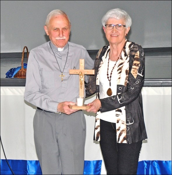 Lumen Christi award in the alumni friend category is presented to Gil Bellavance by Adrienne Welter.