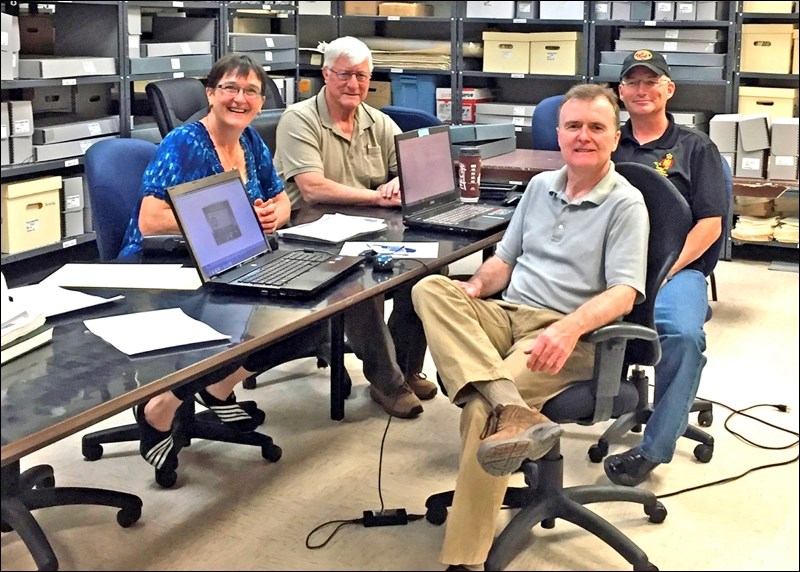 Archivist Tammy Donahue Buziak and archives volunteers Gordon Parkinson and Darren Roberts with Gordon Watson (front), a researcher from Massachusetts. Photos submitted