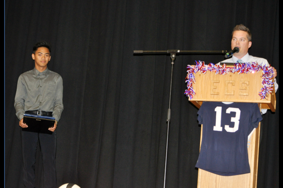 John Sasi, left, listens to senior boys head coach Nathan Wilhelm talking at the ECS awards night