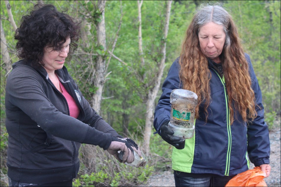 Becky Hyska and Nadine Porter gather discarded Listerine bottles from the side of Highway 10 on June 5. Along with several volunteers, Hyska and Porter have helped lead a number of litter pick-up outings around Flin Flon. - PHOTO BY ERIC WESTHAVER