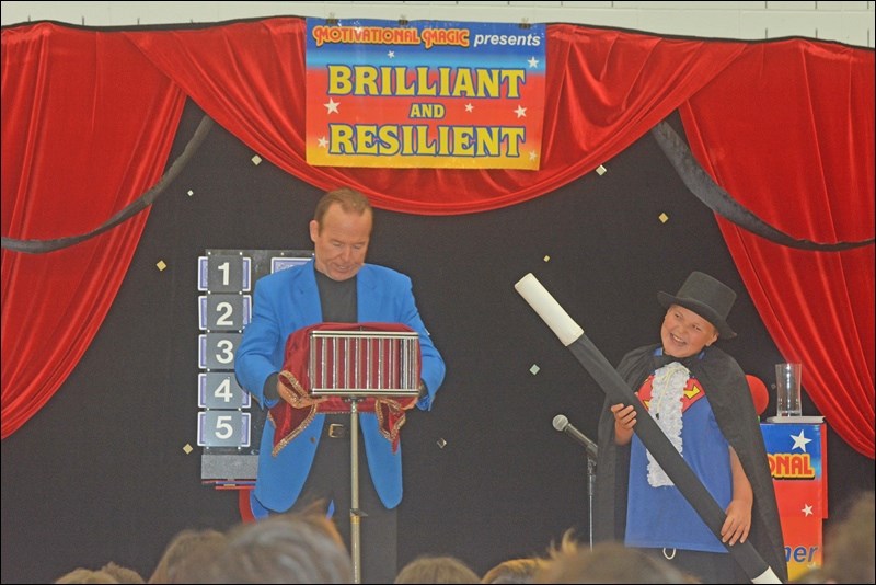 Magician Marvels Connaught — Magician Steve Harmer thrilled Connaught School last week as he brought his magic show to the school's gym. Harmer asked many students to participate, and he gave away magic pencils to lucky students. Harmer taught students about confidence, control and competence, among other things. Presson Gamble after receiving his prize. Photos by Josh Greschner