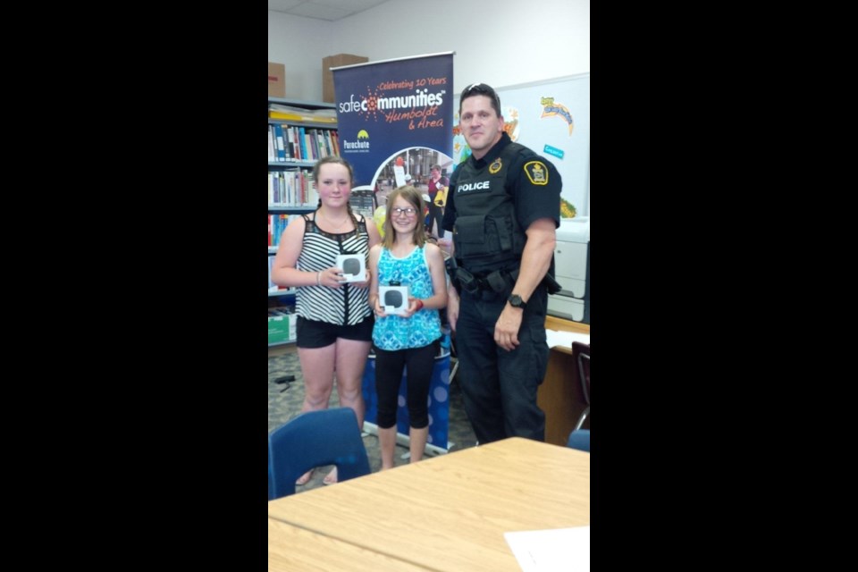 Georgia Strasser and Summer McKnight from Watson School took home the top prize for the Safe Communities #CrossSAFE Rail Safety Program art and video contest for grade 6 students. They won Bluetooth speakers presented by CN Police Service member Cst. Sean Strang during a presentation on June 13. Photos courtesy of Shari Hinz