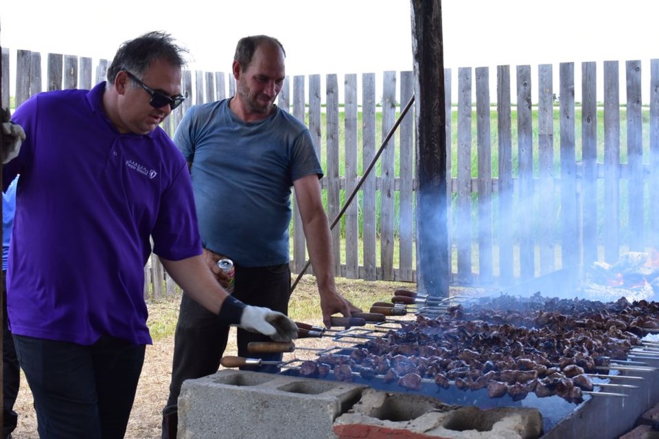 Dereck Wolkowski, left, and Darren Perepelkin were busy at the barbecue on June 30th when the Veregin recreation board sponsored the 74th annual shishliki barbecue, as they were intending to cook 1,200 pounds of meat, expecting to serve about 1,000 people.