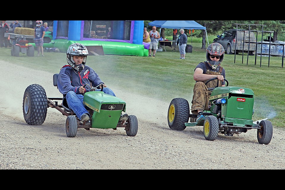 Walker Knutson and Adam Kidd compete in the lawnmower races. Photo by Devan C. Tasa