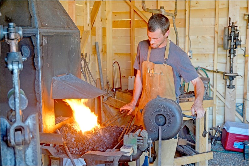Blacksmith Justin Miller doing a demonstration for community members at the new blacksmith shop at the Fred Light Museum. The museum hosted a grand opening for the blacksmith shop Saturday. The building is based on the shop that used to be located at 231 - 21st St. in Battleford. Miller can make a number of things, including crosses, gates and floral designs. Photos by Josh Greschner