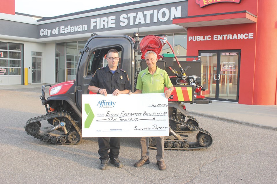 Estevan Firefighters Association president Capt. Kyle Luc accepts a cheque for $10,000 from Affinity Credit Union Southeast District Council representative Duane Chipley.