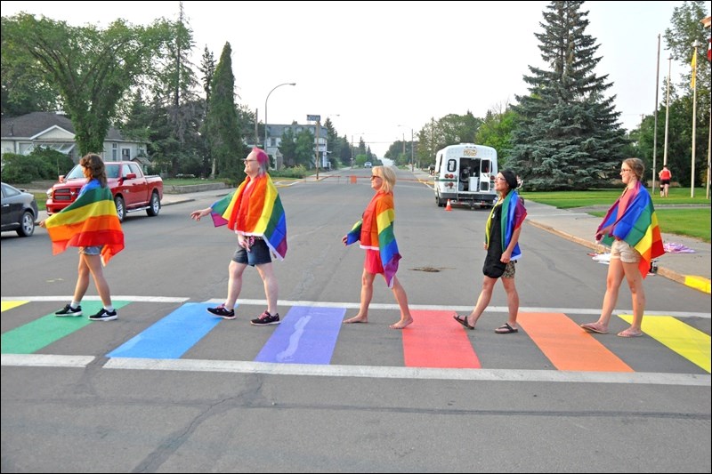 The volunteers who had painted the Rainbow Crosswalk outside Town Hall wanted to show their “Pride” by recreating the Beatles’ Abbey Road album cover. The crosswalk was painted on Thursday evening; the rainbow pride flag was also raised that evening at Battleford Town Hall and will fly through Pride Week. Photos by John Cairns