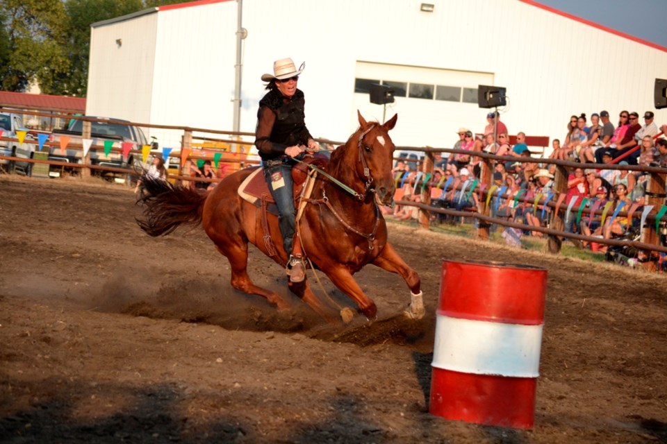 Female athletes race through the barrels at Arcola's Rough Stock Rodeo