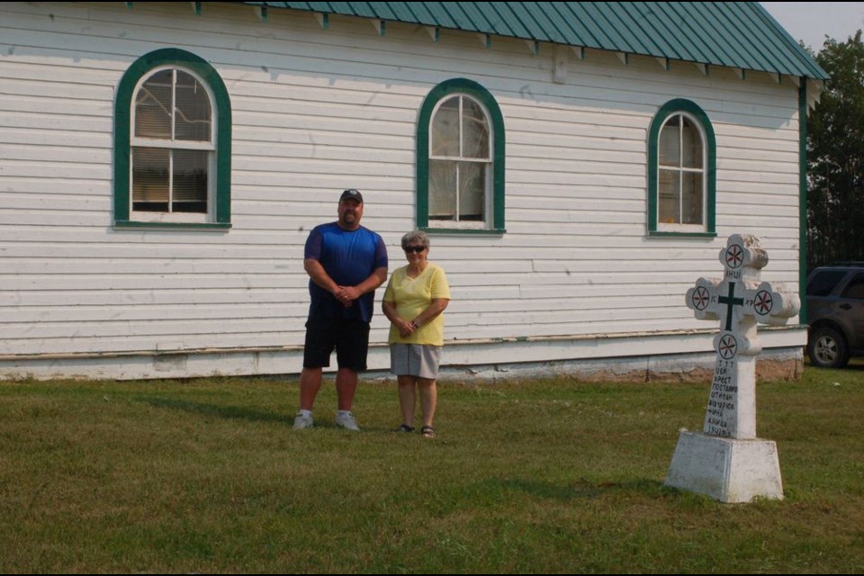 The Greenleaf Orthodox Greek Church members celebrated the churches 75th anniversary on August 11. Greg Gawrelitza, left, and Lorraine Shewchuk, executive committee members, posed for a photograph in front of the church.