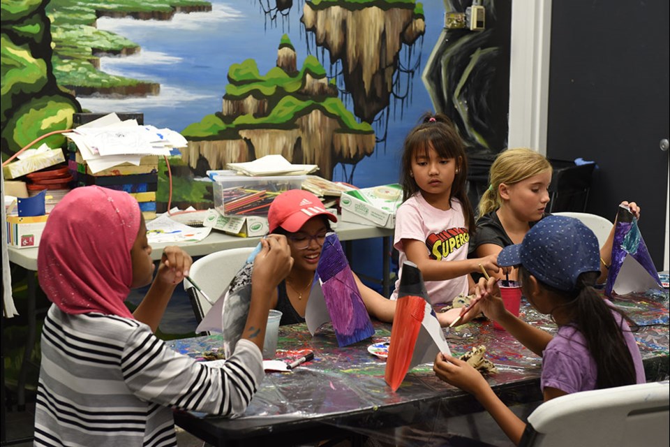 Participants in the Art in Advertising camp play with paints on their last camp day.