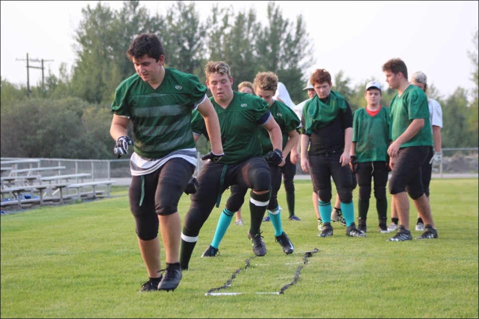 Myles Patterson, Blake Alexander and Austin McLean run through an agility ladder.	Photo by Eric Westhaver