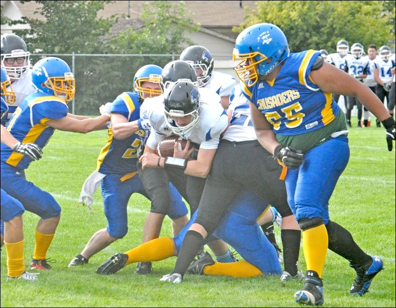 The JPII Crusaders got their season started off right as they thumped the Martensville Royals 33-12. Pictured is JPII’s defence stuffing Maretensville’s offence near the Crusader end zone while Crusader John Panapasa looks on. Also pictured, Leo Senger tries to punch the ball out of the Crusader end zone but is grabbed by Martensville defender Dmytro Kramesh. The Crusaders’ next game is Thursday   at Meadow Lake, and they return home Sept. 20 to play Rosetown. Photos by Josh Greschner