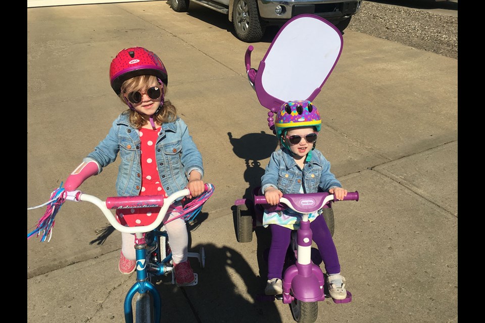 Emma Grobbink, pictured here with her sister Madelyn, is a child amputee born without part of her right hand. A special recreational device allows her to enjoy such activities as riding a bicycle. Photo submitted