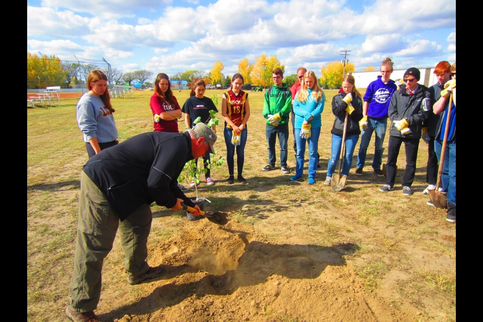 Kelvin Kelly, a community adviser for Tree Canada, instructs LCBI students on the best way to go about planting trees.