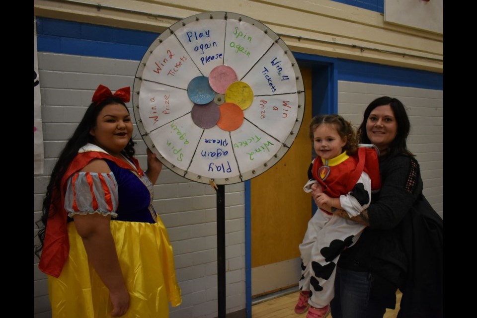 Breanne Andrychuk held her niece Ivy Jane so she could reach and spin the Magical Wheel of Fortune, a game run by Grade 12 student Tanisha Severight at the KCI Fairy tale Fun Night held October 25.