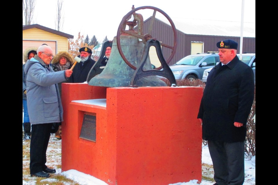 Outlook Mayor Ross Derdall tolls the bell while Legion Branch #262 President Mike Frantz stands by.