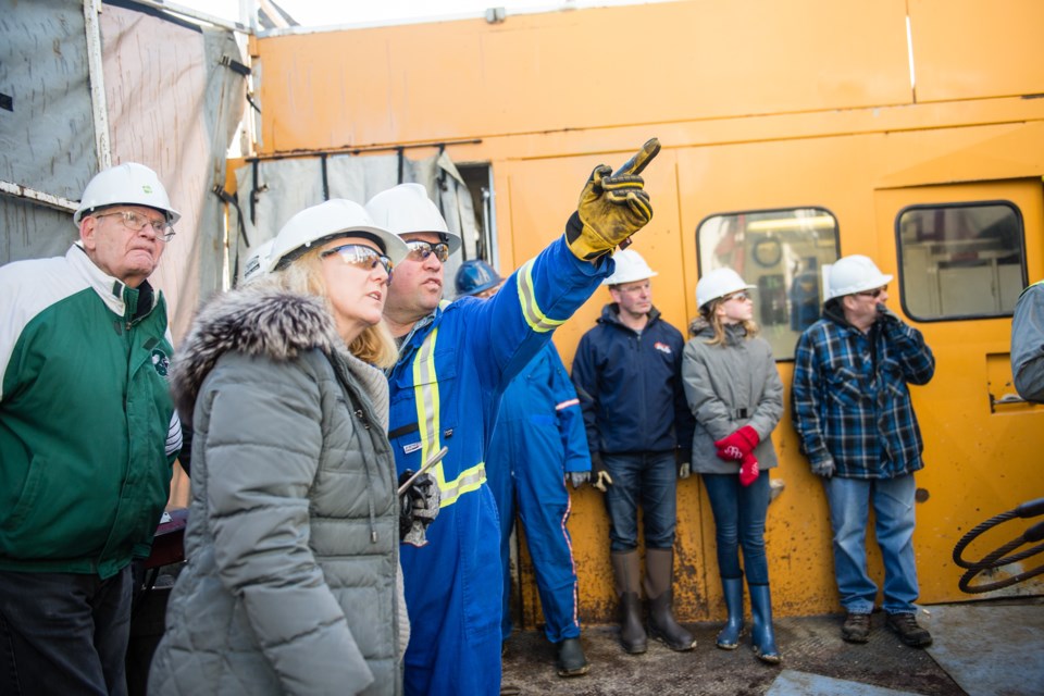 Jon Saunders, one of the wellsite consultants, points out the weight indicator on the derrick.