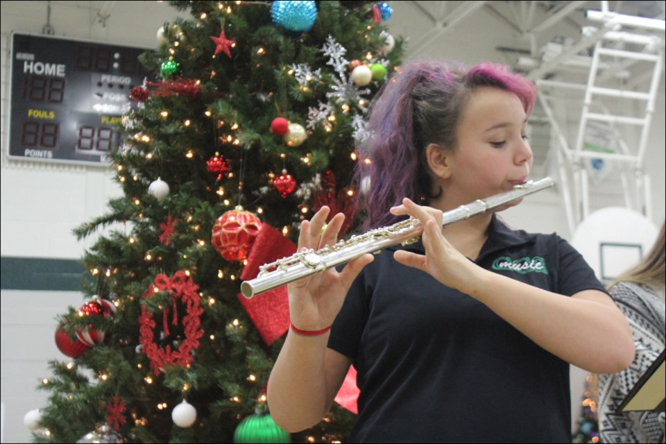 Creighton Community School band student Electa Dean-Asmus played festive tunes in front of a Christmas tree at the school’s Festival of Trees event on Nov. 24. The school holds the event each year, both to provide a holiday market for local businesses and shoppers, and to raise money for area groups. - PHOTO BY ERIC WESTHAVER