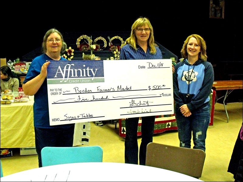 Peggy Walker and Lynette Schmidt present $500 from Affinity Credit Union to Karen Kerr for the Borden Farmers’ Market