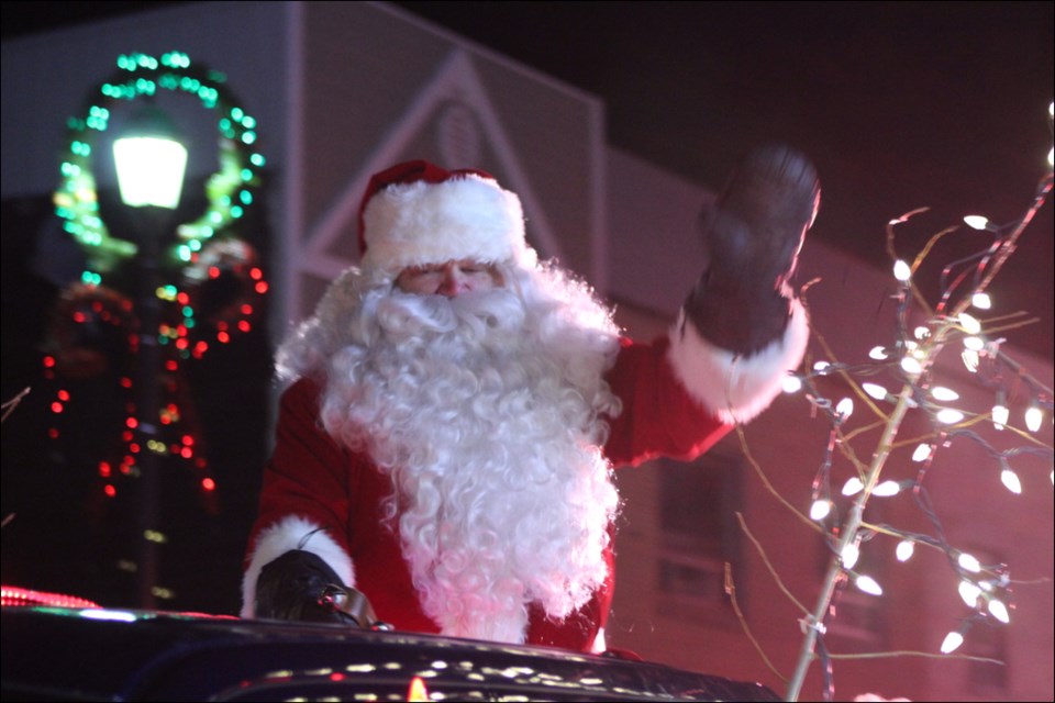 Santa Claus waves to holiday wellwishers during the parade.