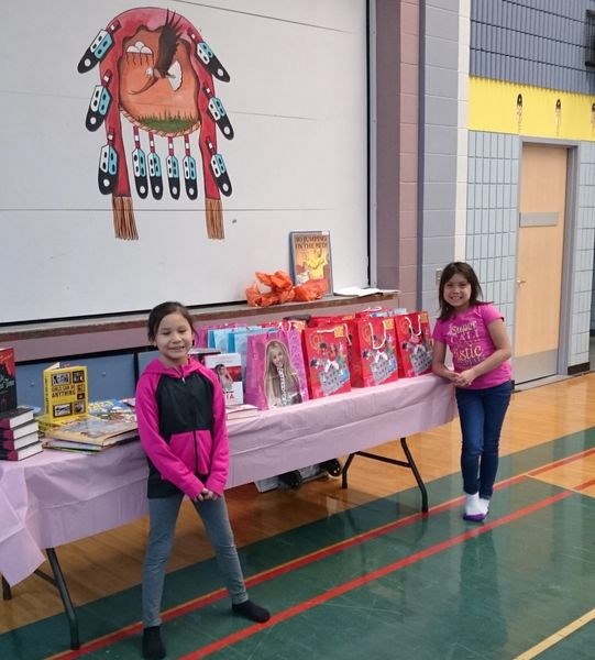 At Family Literacy Fun Night held at Keeseekoose Chief’s Education Centre (KCEC) on November 28, Charlee Moccasin (left) and Quinn Keshane stood beside a table filled with books and bags in which to take the books home.