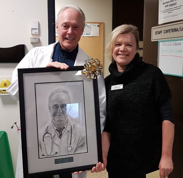 Lorelee Davis, health services manager with the Sunrise Health Authority, presented Dr. Murray Davies with a framed portrait of himself which was created by Dustin Wilson, a local artist of Dustin Wilson Art.