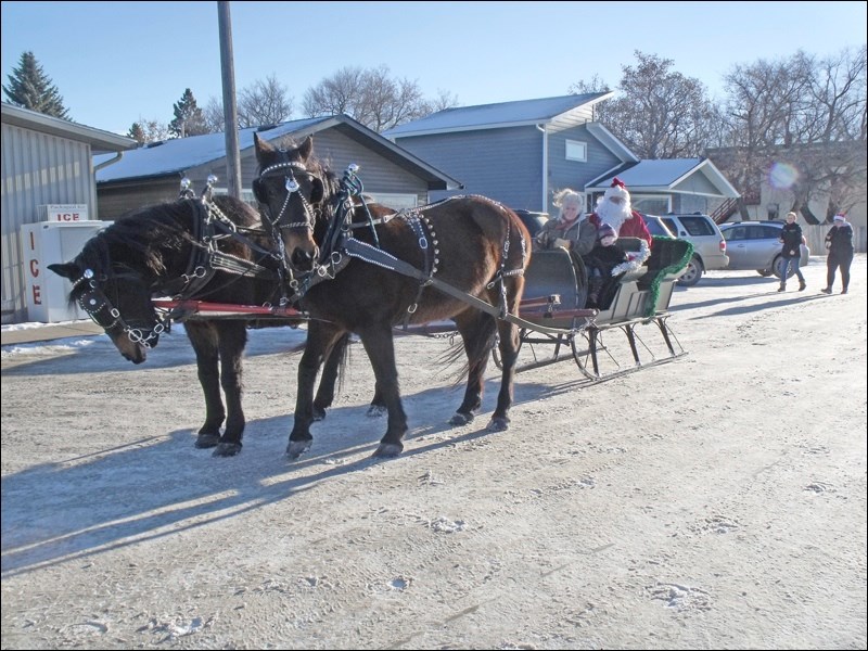 Santa riding in a sleigh driven by Laura Unruh and her granddaughter Ivy. Photos by Lorraine Olinyk