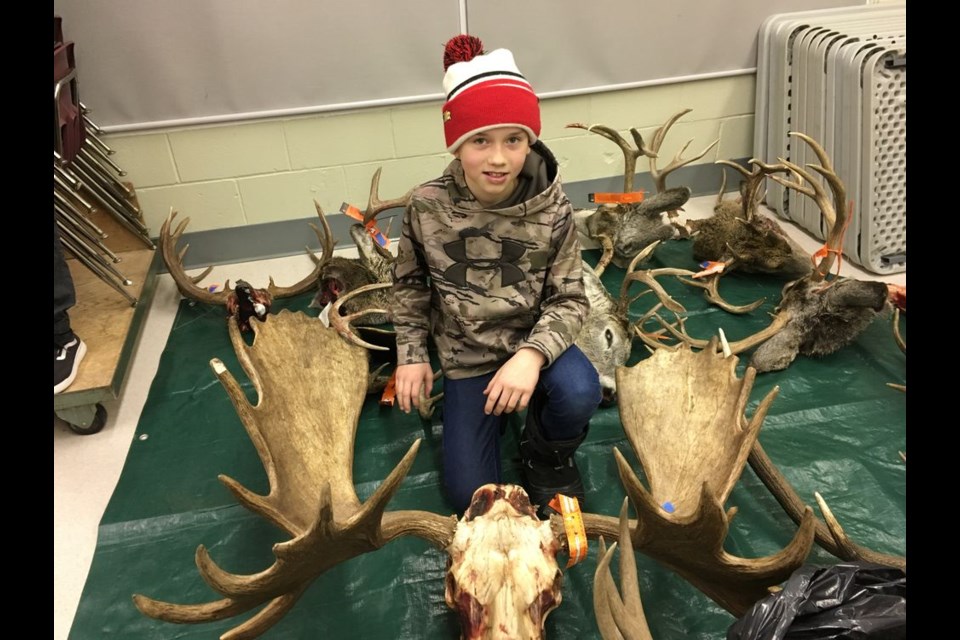 Devon Paley proudly showed off his dad Damon’s moose antlers at the antler measuring.