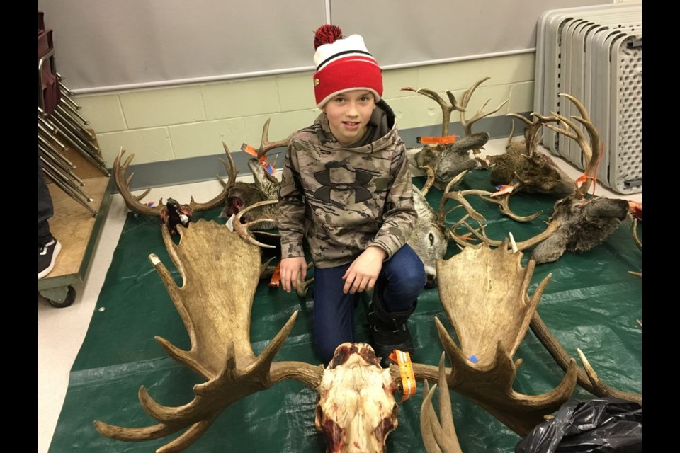Devon Paley proudly showed off his dad Damon’s moose antlers at the antler measuring.