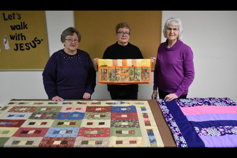 In addition to sewing quilt covers for quilts which are donated to Victoria’s Quilts for Cancer, members of the Kamsack Heart and Home Quilt Club find time to sew personal projects. From left, Lydia Thomas displayed her quilt cover made with leftover strips of two-and-a-half-inch fabric, Colleen Koroluk displayed her “bumfab” headboard caddy and Marj Orr displayed her quilt which was to be donated for inclusion in a Christmas hamper.