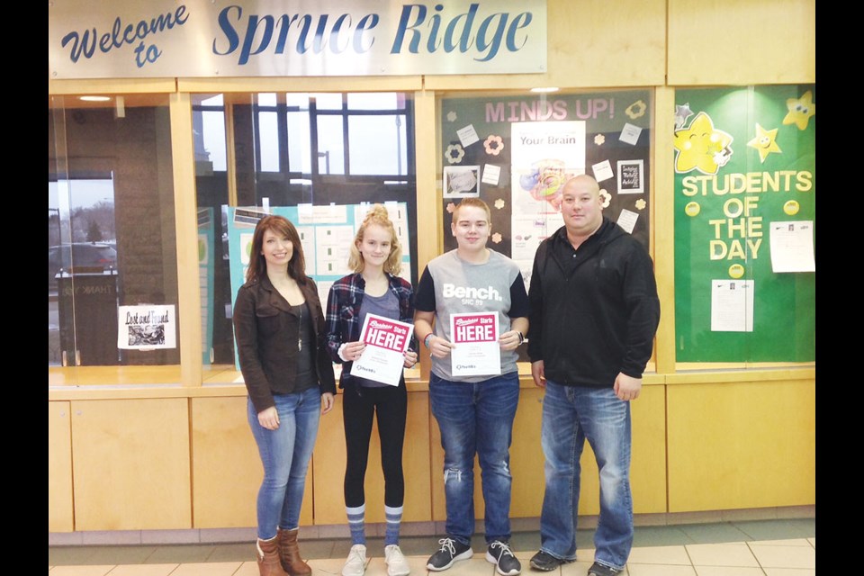 From left, Verna O’Neill from Community Futures Sunrise presents first prize in the Grade 6-8 category to Spruce Ridge School students Sydney Clausen and Conner Piche, and teacher Graeme Summer. Photo submitted
