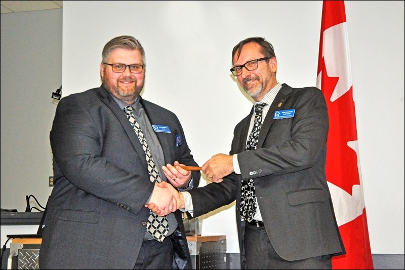 Dallan Oberg takes the gavel from outgoing Chair Terry Caldwell as the new chair of the Battlefords Chamber of Commerce.