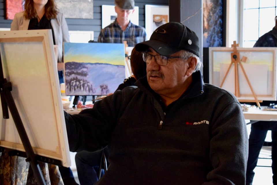 Cree artist Michael Lonechild was working on his piece along with the students, explaining and demonstrating how to do art. Photo by Anastasiia Bykhovskaia