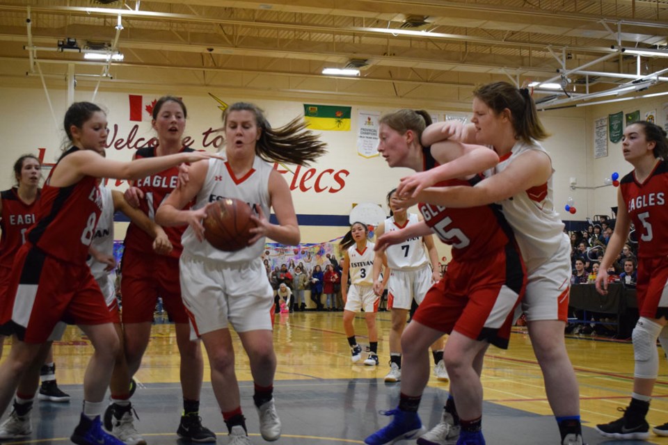 Jennica Memory of the Elecs grabs the rebound with Estevan and Weyburn players nearby.