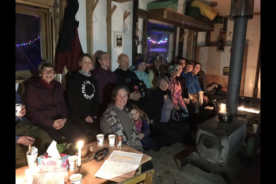 During the Good Spirit Cross Country Ski Club’s ninth annual Lamplighter Loppet on February 16, a group of skiers huddled together to enjoy hot chocolate and good company in the warmup shelter by the fire. The brightly lit Loppet course was visible through the windows behind them.