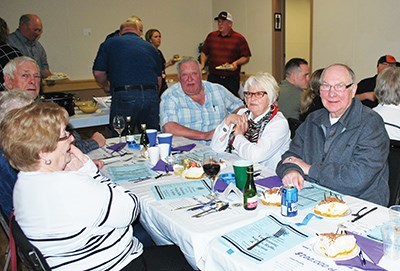 A good crowd was once again on hand at the annual Carlyle Lions Auction and Supper held March 7. These folks were seen enjoying a piece of the pie Frank Faber bought. The delicious pie was made by Lion Dennis Feduk. (Photo by Mary Moffatt)