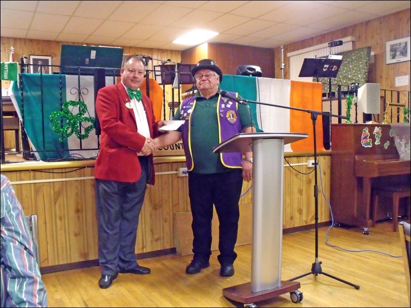 Lions President Perry presenting a cheque to District Governor Thomas Schwab. Photos by Lorraine Olinyk