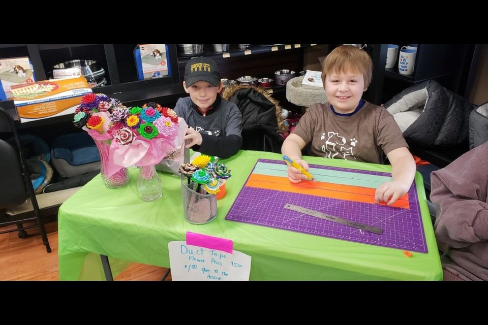 Wyatt Scheller, 9, (left) and his brother Carter, 11 make duct tape flowers.