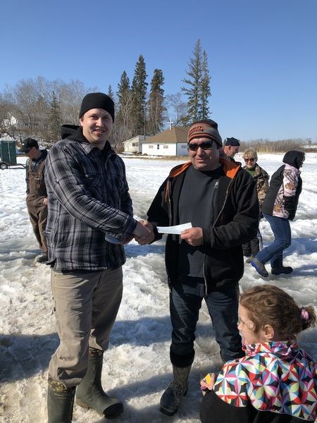 Darren Descalchuk, right, won the first prize for the biggest and first fish caught at the Nelson Lake ice fishing derby on March 23. Michael Yaremchuk, club representative made the presentation.