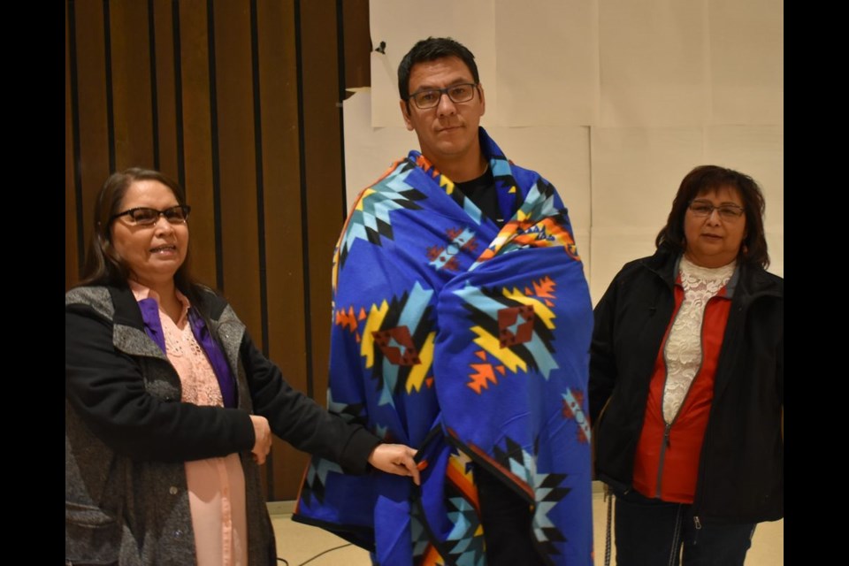 Jamie Desjarlais of New Beginnings Outreach in Kamsack was presented with a blanket for his contribution to the event by Enola Friday, right, and Marion Whitehawk. All three were event organizers.