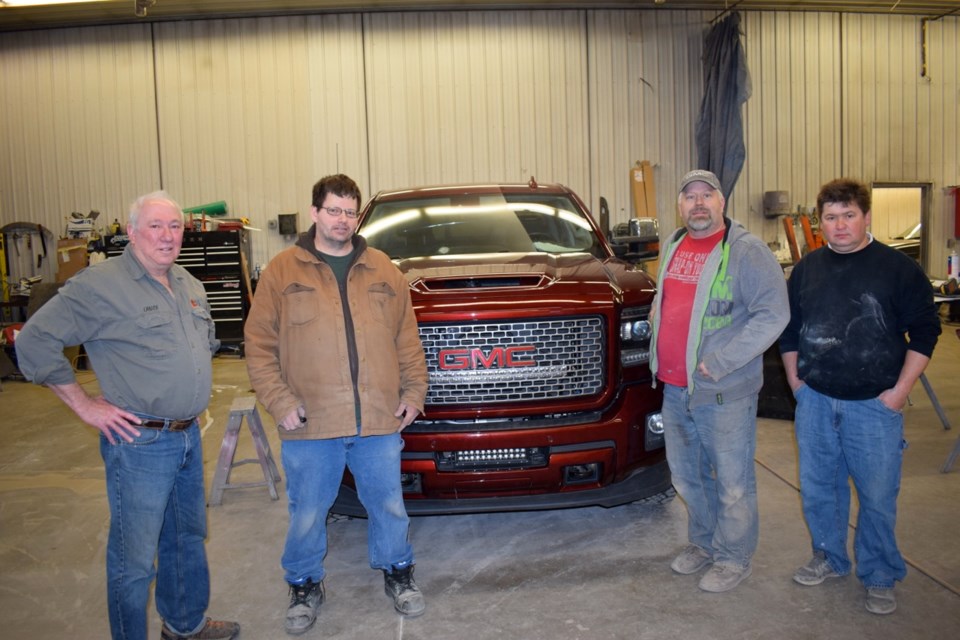 From left, Lance Mack, Neil Marshall, Ron Ratashniak and Alex Kretts flank one of vehicles being worked on at Cactus Autobody.