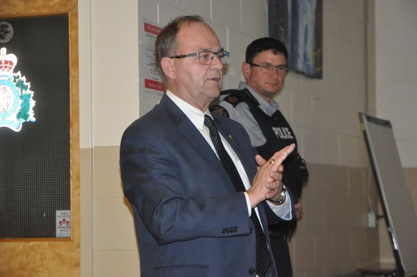 Battlefords MLA Herb Cox, seen here with Sgt. Jason Teniuk behind him, was there as well to explain more about the Saskatchewan Crime Watch Advisory Network. The expansion of that network was announced earlier that day. Photo by John Cairns