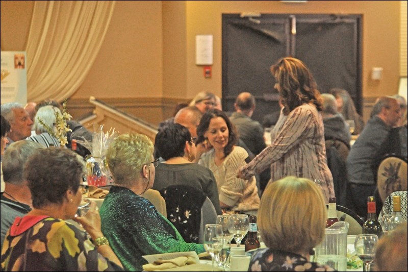 Scenes from the live auction portion of the Battlefords Humane Society gala. Executive Director Michelle Spark shows off some of the auction items, including a diamond ring.