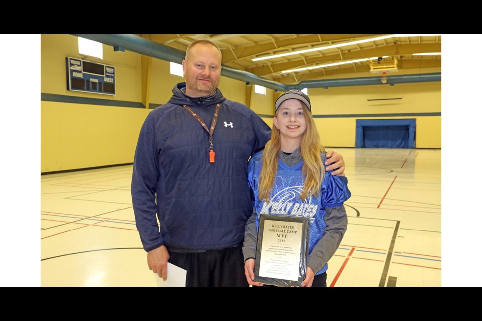 Kelly Bates, left, presented the most valuable player at his football camp to Emily Yanish. Yanish is the first female player in the history of the camp to receive the award. Photo by Devan C. Tasa