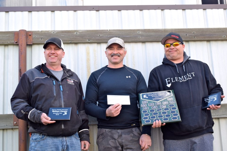 Rene Sehn, left, and Shane Smith, right, received cheques for the biggest basket and the biggest fish caught from Michael Halirewich, fisheries chairman for Estevan Wildlife Federation. Photo by Anastasiia Bykhovskaia