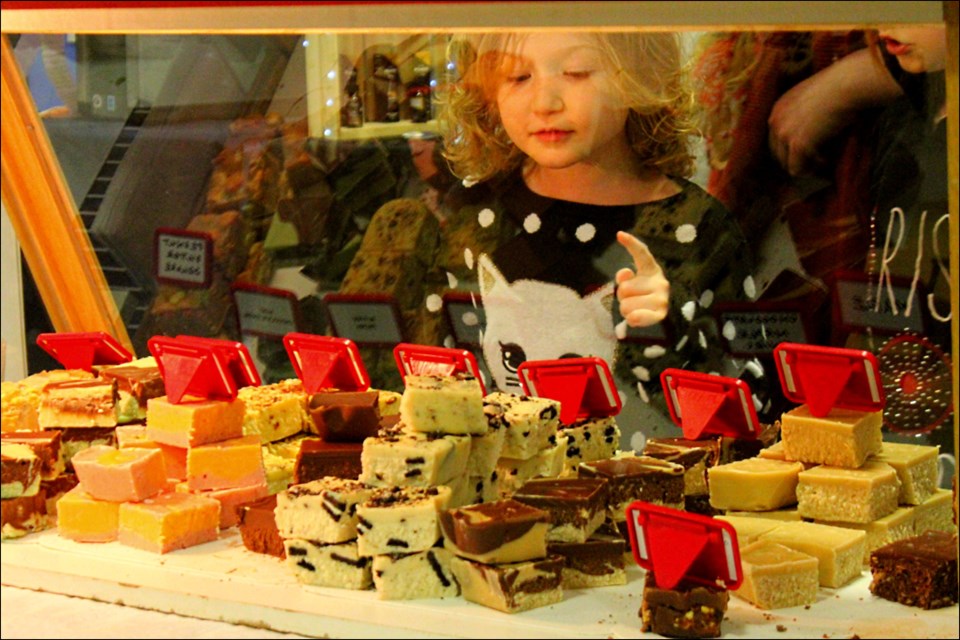 Anne Watkins stares with delight at the Sweets fudge display. - PHOTO BY ERIC WESTHAVER