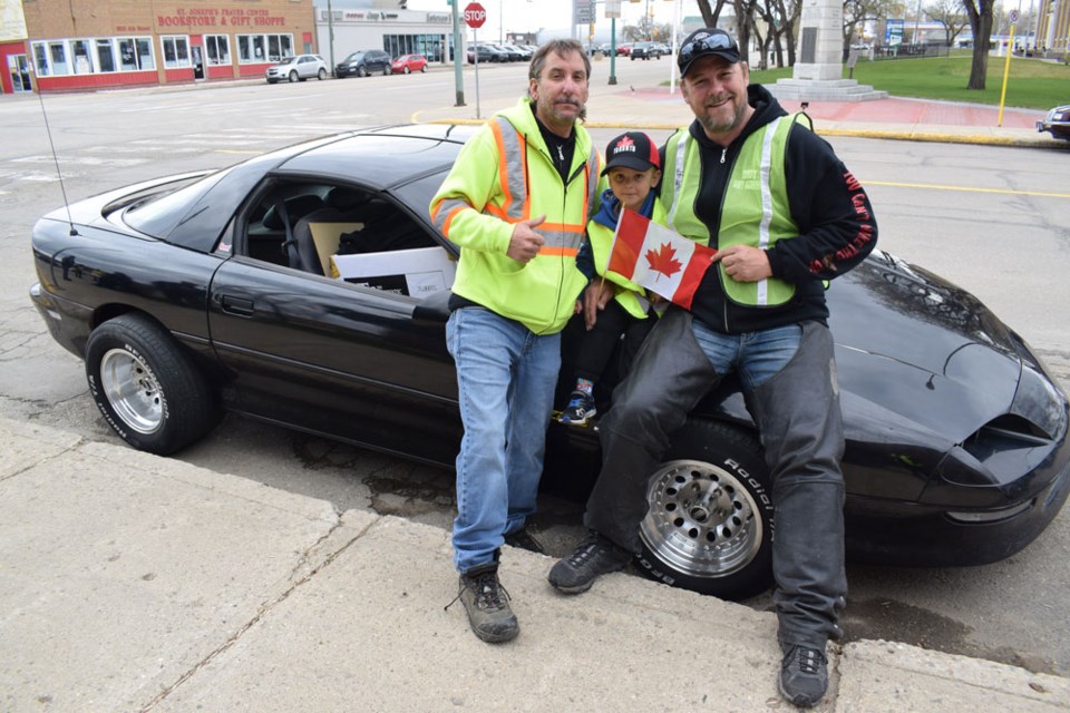 Jay Riedel, left, and Pat King, right, pictured here with Riedel's great-nephew Kaiden Curtis, were in Estevan Saturday for the Yellow Vest protest.