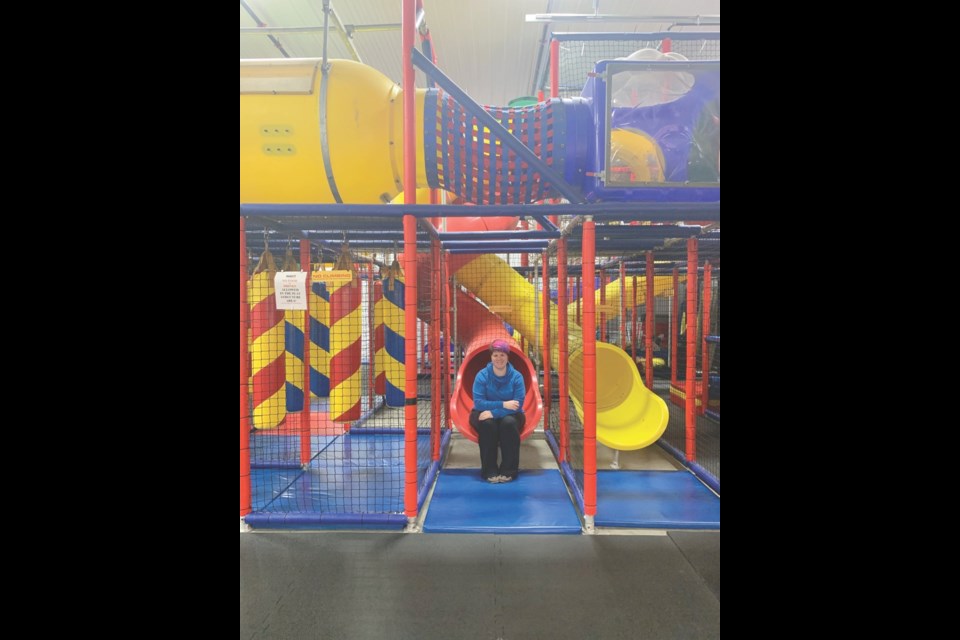 Melissa Mosley sits at the foot of the slide inside the Energy Outlet Indoor Play Zone. Photo submitted